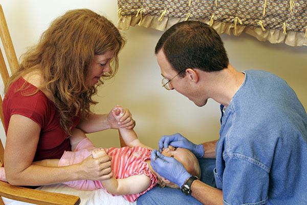 Baby with parent and dentist